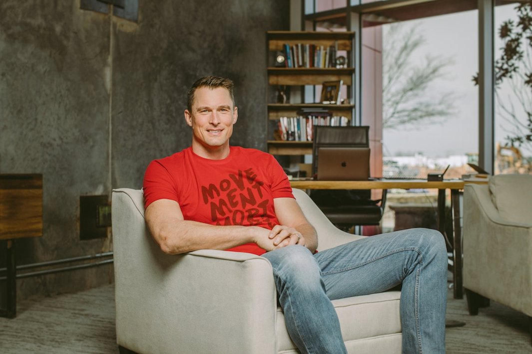 Casey sitting on chair with red movement shirt